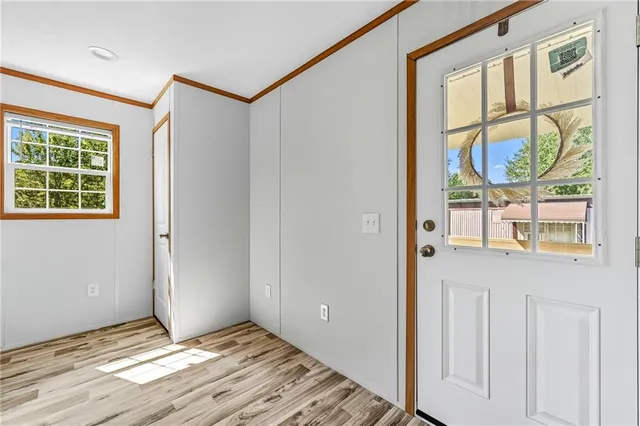 a view of an empty room with wooden floor and windows