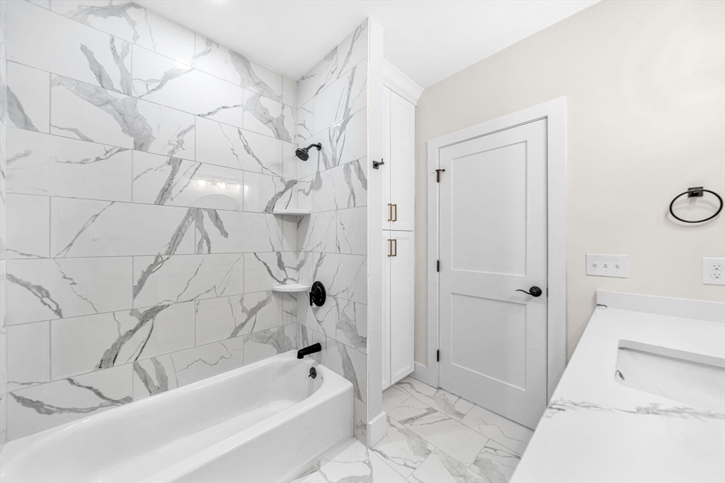 441 Washington Street, Unit 305 Dedham, MA 02026 - Photo 7 of 20 a bathroom with a bathtub and a shower
