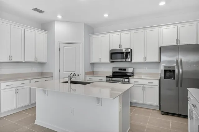 a kitchen with kitchen island a sink stainless steel appliances and cabinets