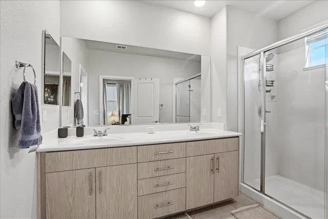 a bathroom with double sink and a mirror