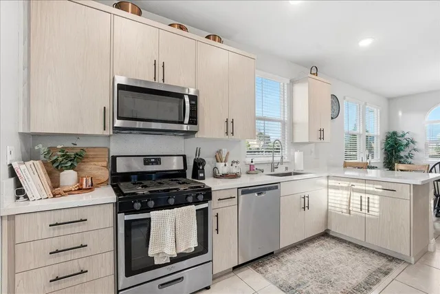 a kitchen with granite countertop white cabinets stainless steel appliances and a sink