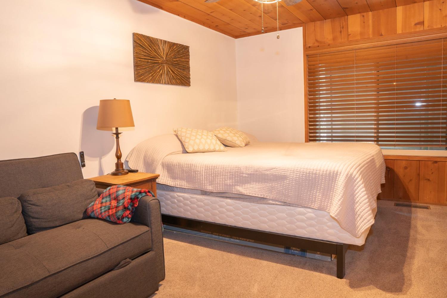 42135 Hanging Branch Road Shaver Lake, CA 93664 - Photo 46 of 55 a bedroom with a bed and a couch