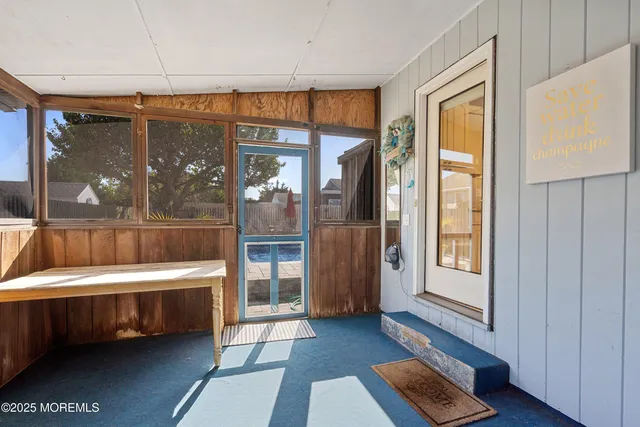 a bedroom with a bed table chair and a window