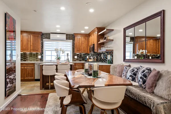 a dining room with furniture a large window and kitchen view