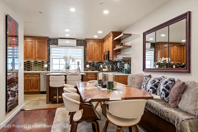 a dining room with furniture a large window and kitchen view