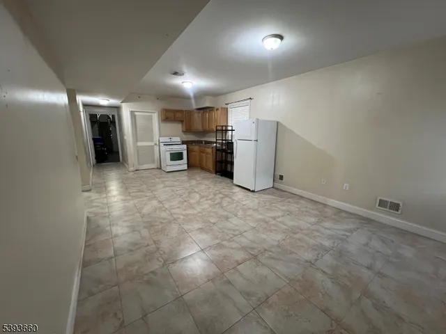 a view of a refrigerator in kitchen and utility room
