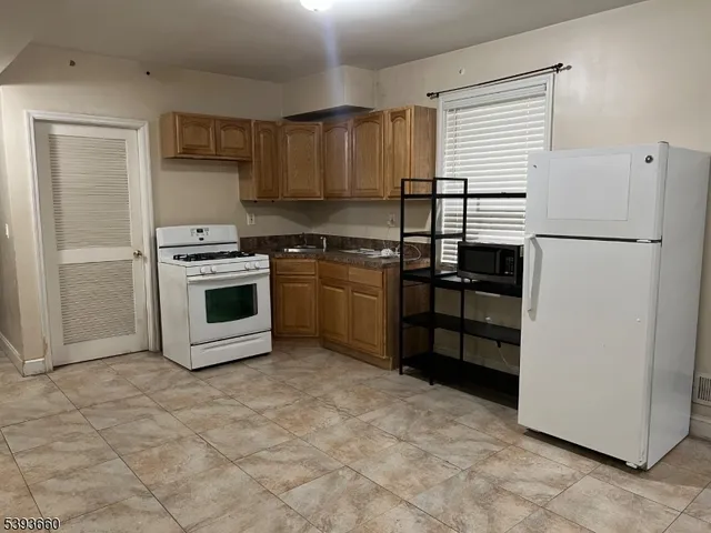 a kitchen with a refrigerator sink and cabinets