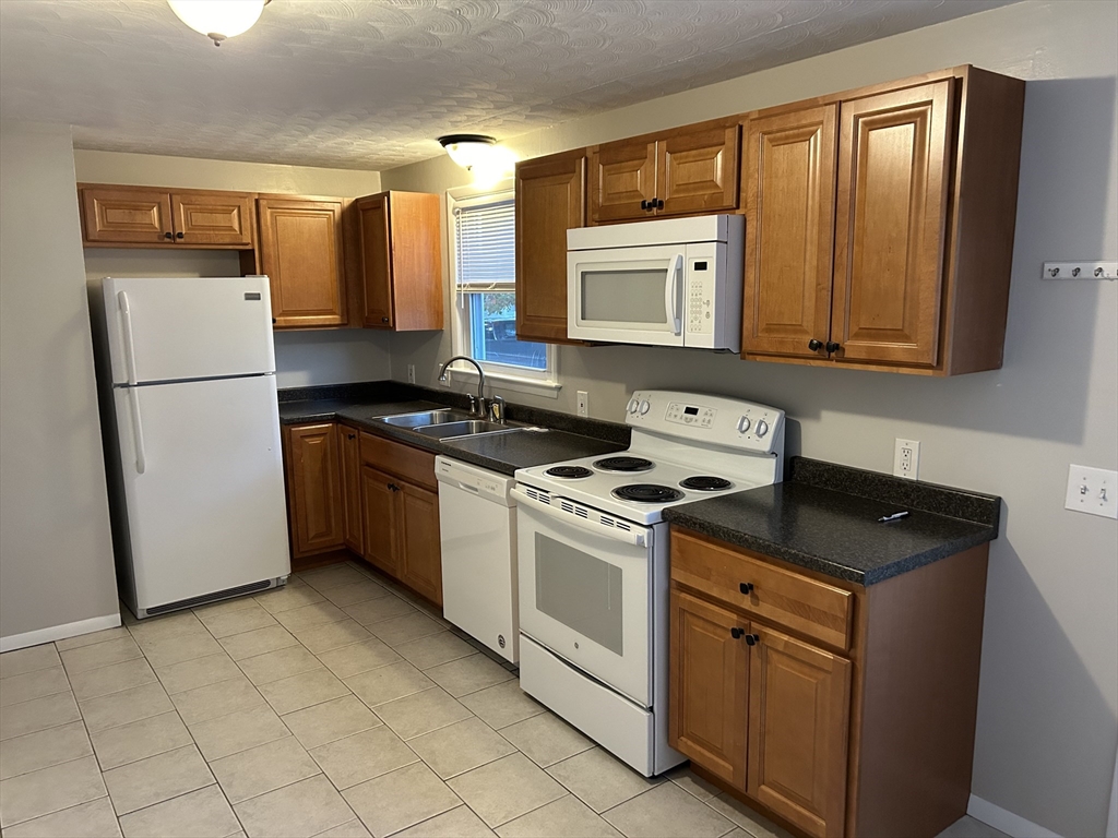 48 Hope Street Springfield, MA 01119 - Photo 3 of 9 a kitchen with a stove a sink and a refrigerator