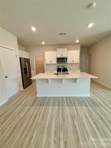 a view of kitchen with sink microwave and refrigerator