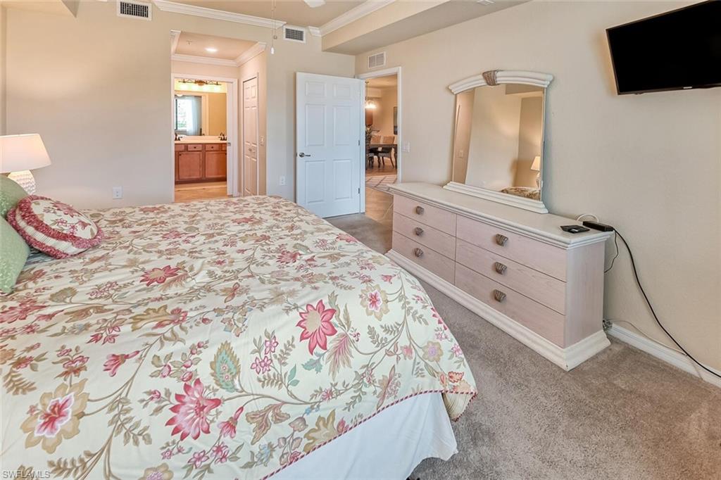 9528 Avellino Way, Unit 2515 Naples, FL 34113 - Photo 13 of 35 a bedroom with a bed and a mirror on dresser