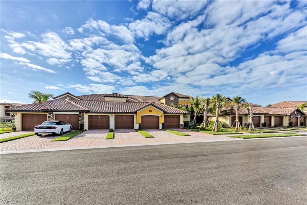 9528 Avellino Way, Unit 2515 Naples, FL 34113 - Photo 23 of 35 front view of a building with a garden and trees