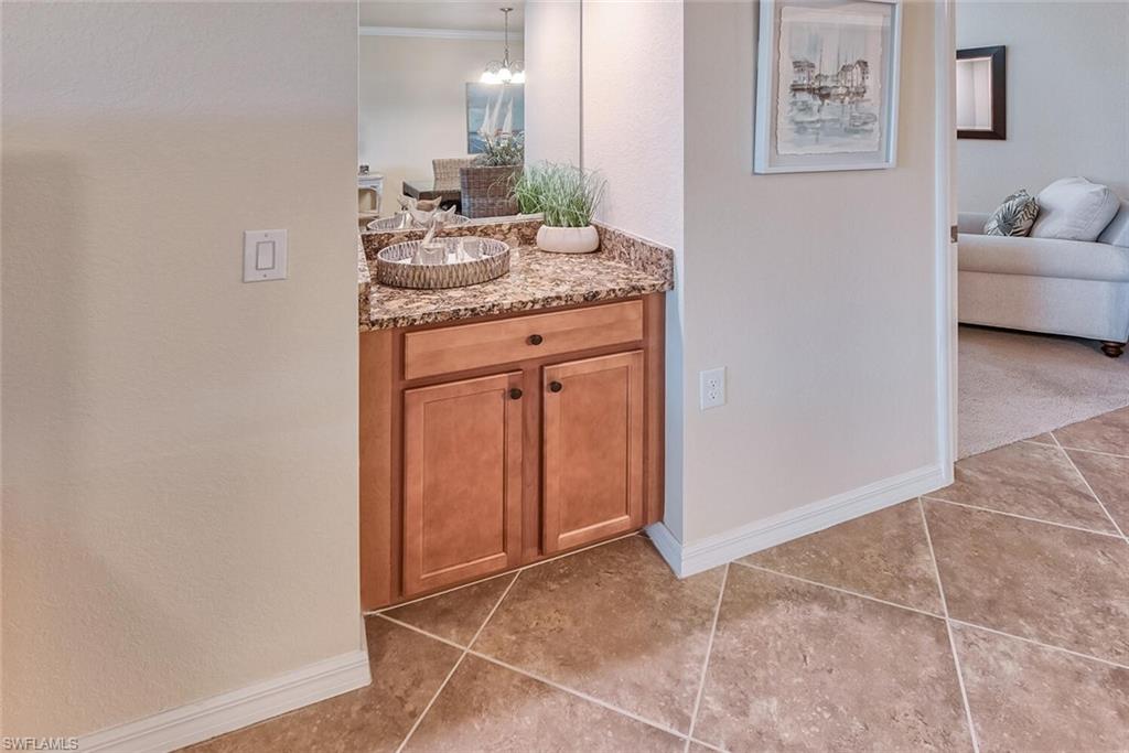 9528 Avellino Way, Unit 2515 Naples, FL 34113 - Photo 8 of 35 a bathroom with a granite countertop sink and a mirror