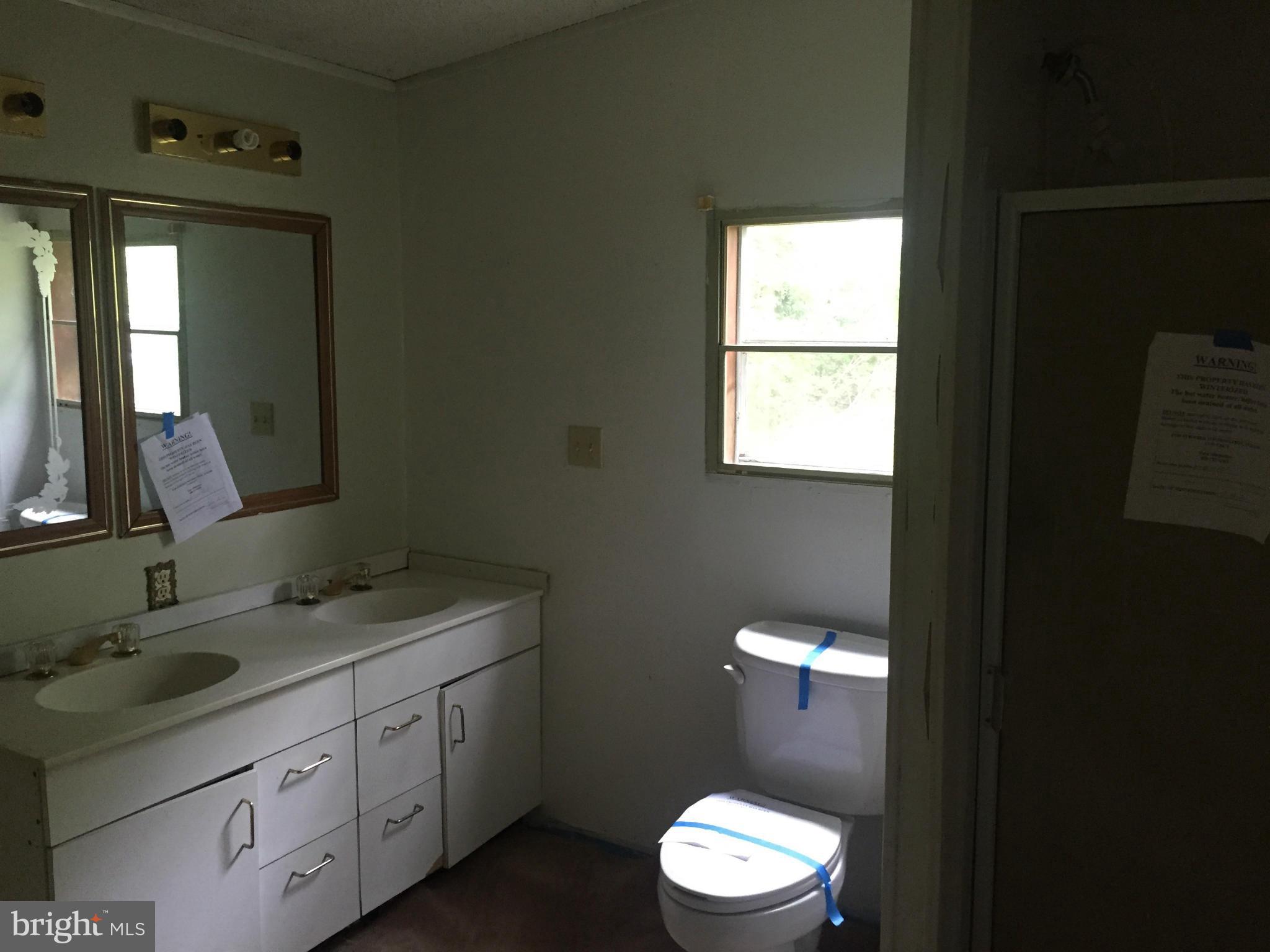 4970 Harmony Road Preston, MD 21655 - Photo 12 of 18 a bathroom with a double vanity sink and a mirror