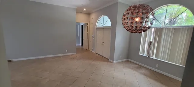 an empty room with a large window and chandelier