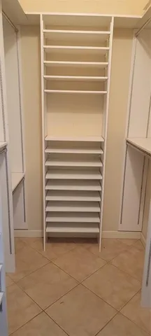 a view of walk in closet with empty racks