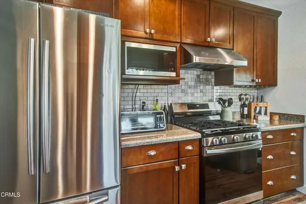 a kitchen with stainless steel appliances granite countertop a stove a sink and a microwave