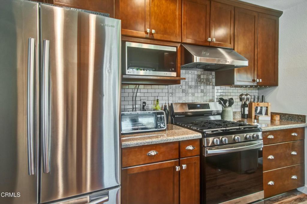 508 Village Road Port Hueneme, CA 93041 - Photo 11 of 38 a kitchen with stainless steel appliances granite countertop a stove a sink and a microwave