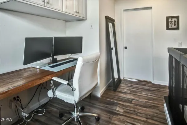 a view of a workspace with furniture and wooden floor