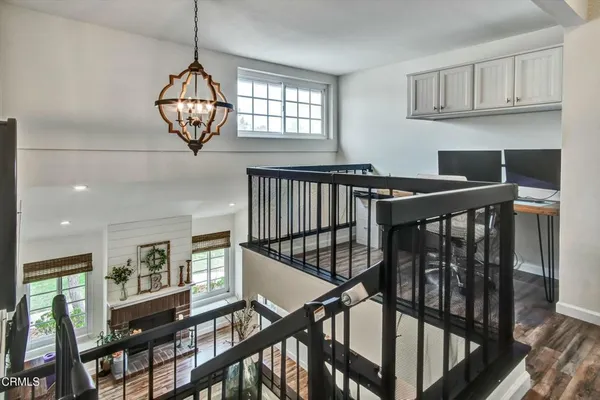 a view of staircase with wooden floor and pendant lights