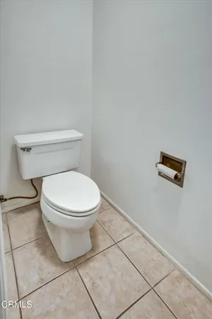 a white toilet sitting next to a white wall