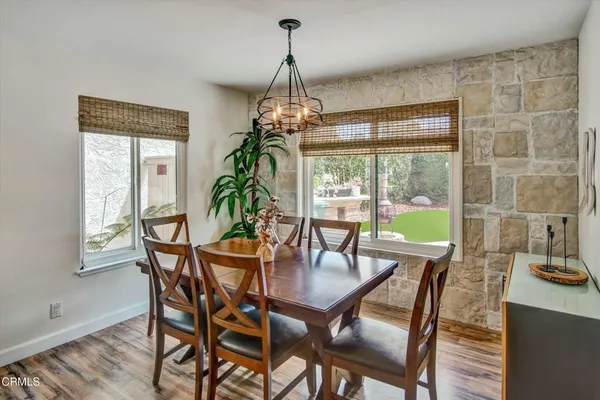 a dining room with furniture a chandelier and wooden floor