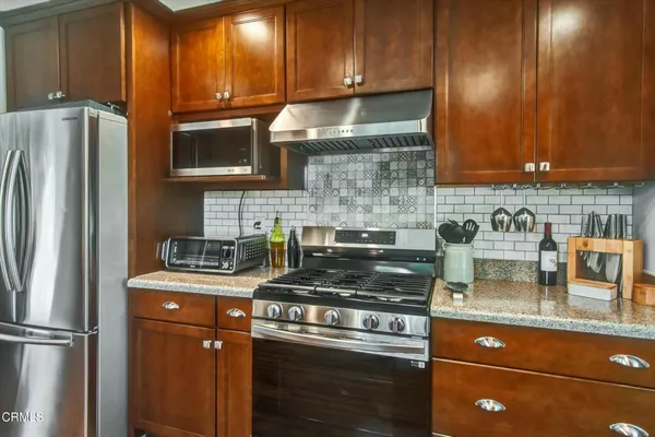 a kitchen with granite countertop stainless steel appliances and wooden cabinets