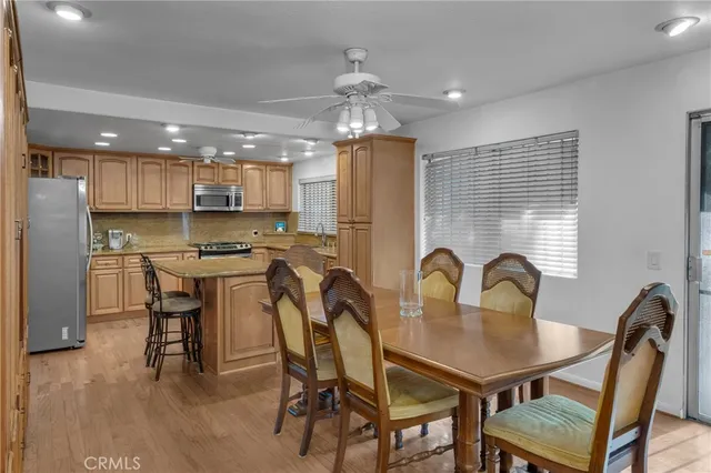 a kitchen with a dining table chairs refrigerator and cabinets