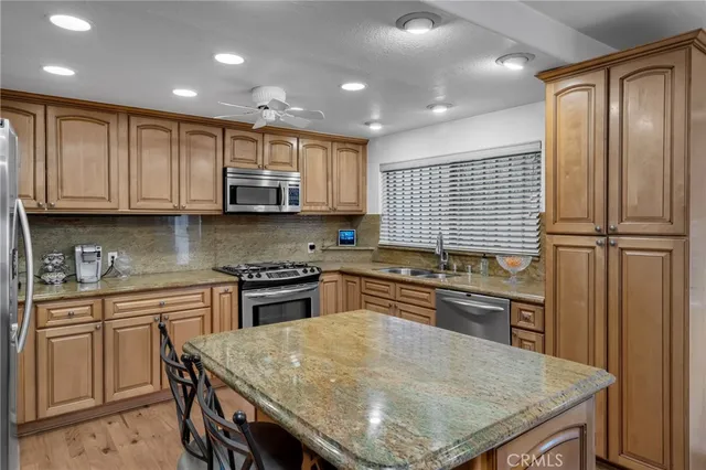 a kitchen with stainless steel appliances granite countertop wooden cabinets a stove top oven a sink and dishwasher