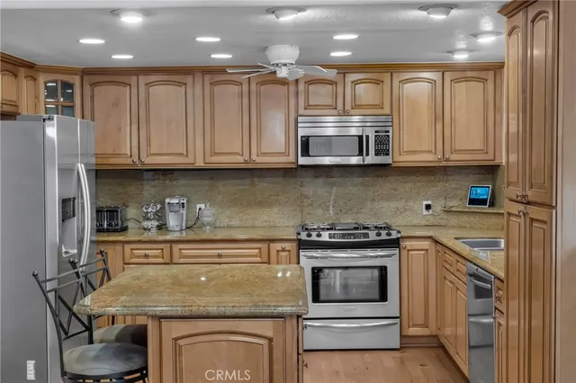 a kitchen with stainless steel appliances granite countertop a stove and cabinets