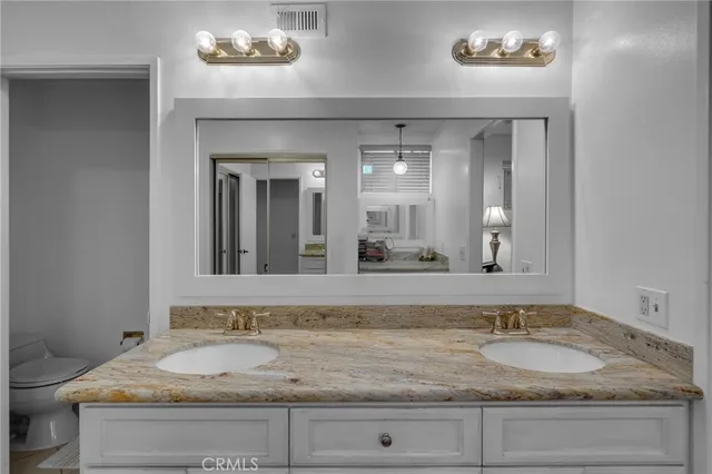 a bathroom with a granite countertop sink and a mirror