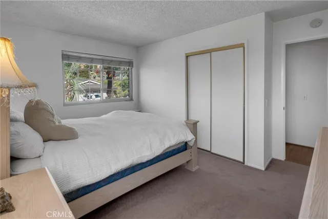 a large bed sitting in a bedroom next to a window