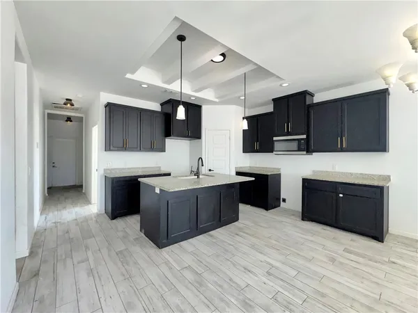 a large kitchen with stainless steel appliances kitchen island granite countertop a stove and a sink