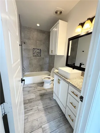 a bathroom with a granite countertop sink mirror vanity and toilet