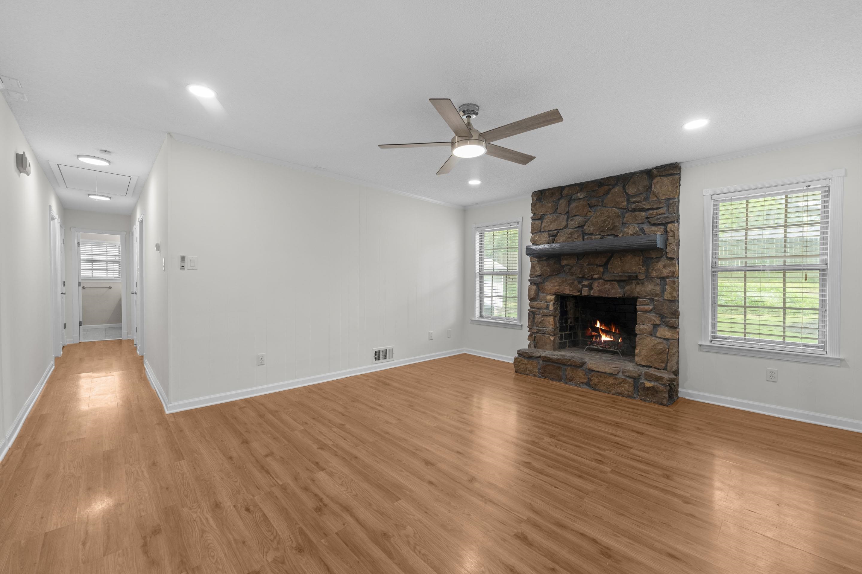 499 Duscoe Street Collierville, TN 38017 - Photo 8 of 38 an empty room with wooden floor a fireplace and a window