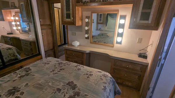 a bedroom with a bed and a mirror on dresser
