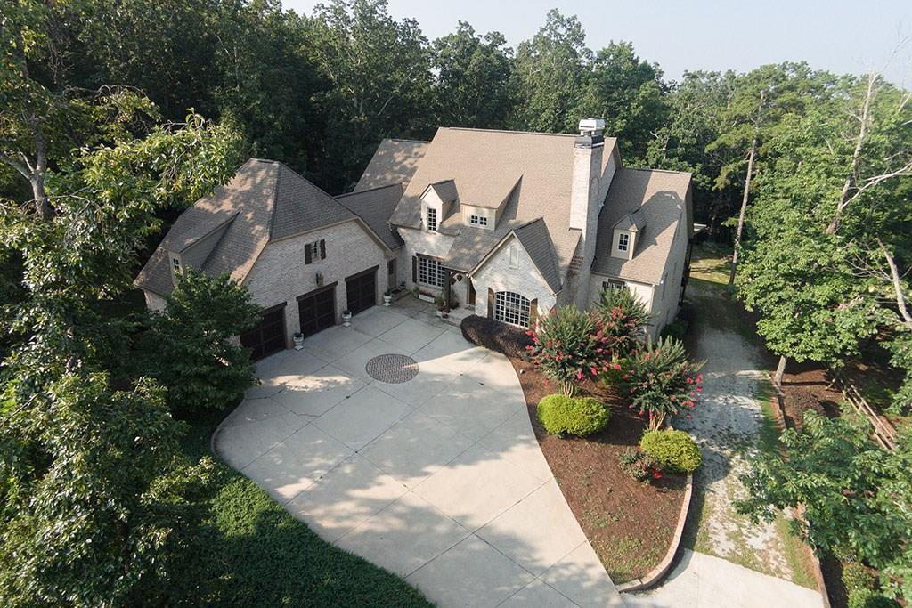 an aerial view of a house with garden space and trees