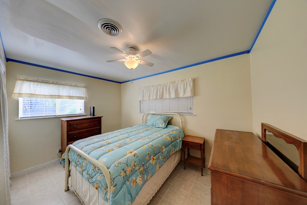 206 Austin Street Ingram, TX 78025 - Photo 13 of 18 a bedroom with a bed and a chandelier