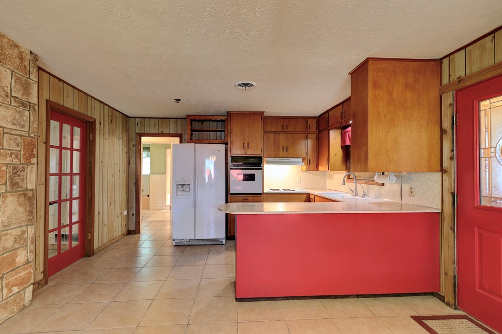 206 Austin Street Ingram, TX 78025 - Photo 5 of 18 a kitchen with stainless steel appliances granite countertop a sink stove and refrigerator