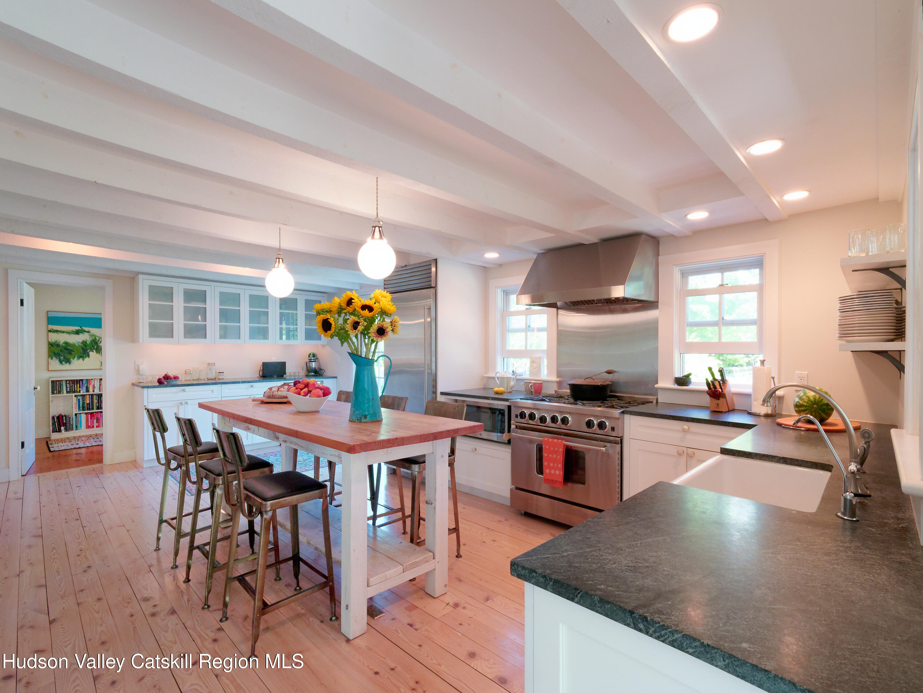 5 Fulton Homestead Road Red Hook, NY 12571 - Photo 16 of 41 a kitchen with stainless steel appliances granite countertop a stove top oven a dining table and chairs with wooden floor