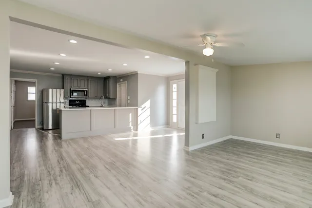 a view of a kitchen with a sink and wooden floor