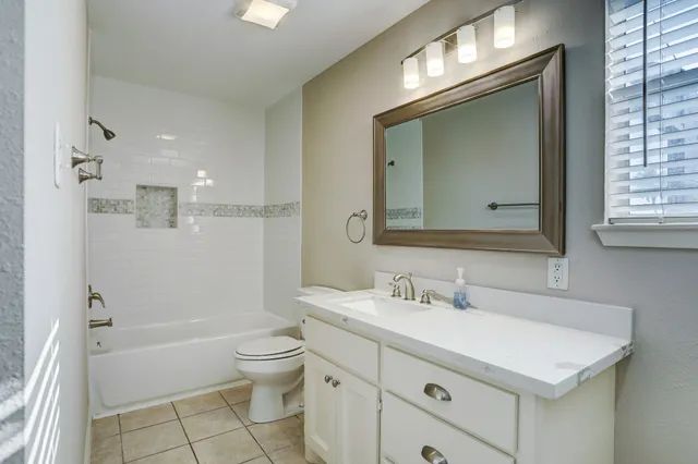 a bathroom with a sink a toilet and a large mirror