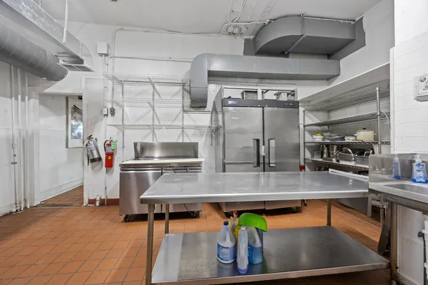 a kitchen with stainless steel appliances granite countertop a sink a stove and a refrigerator