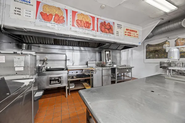 a open kitchen with stainless steel appliances granite countertop a stove top oven a sink a counter space and cabinets