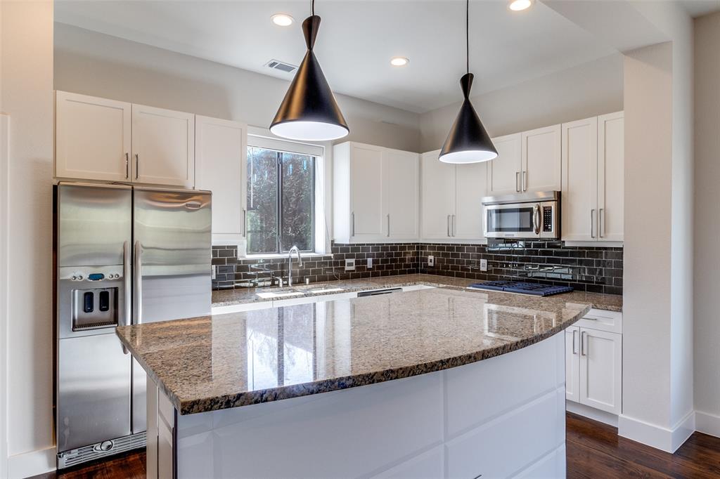4211 Rawlins Street, Unit 530 Dallas, TX 75219 - Photo 10 of 33 a kitchen with stainless steel appliances granite countertop a sink and a refrigerator