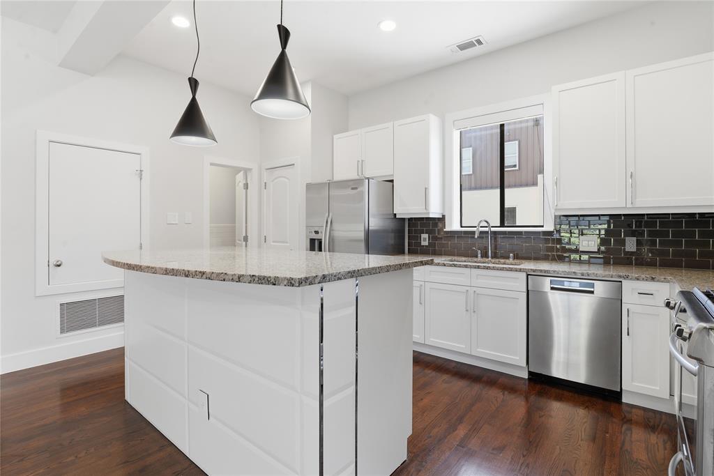 4211 Rawlins Street, Unit 530 Dallas, TX 75219 - Photo 12 of 33 a kitchen with stainless steel appliances granite countertop a stove a sink and white cabinets