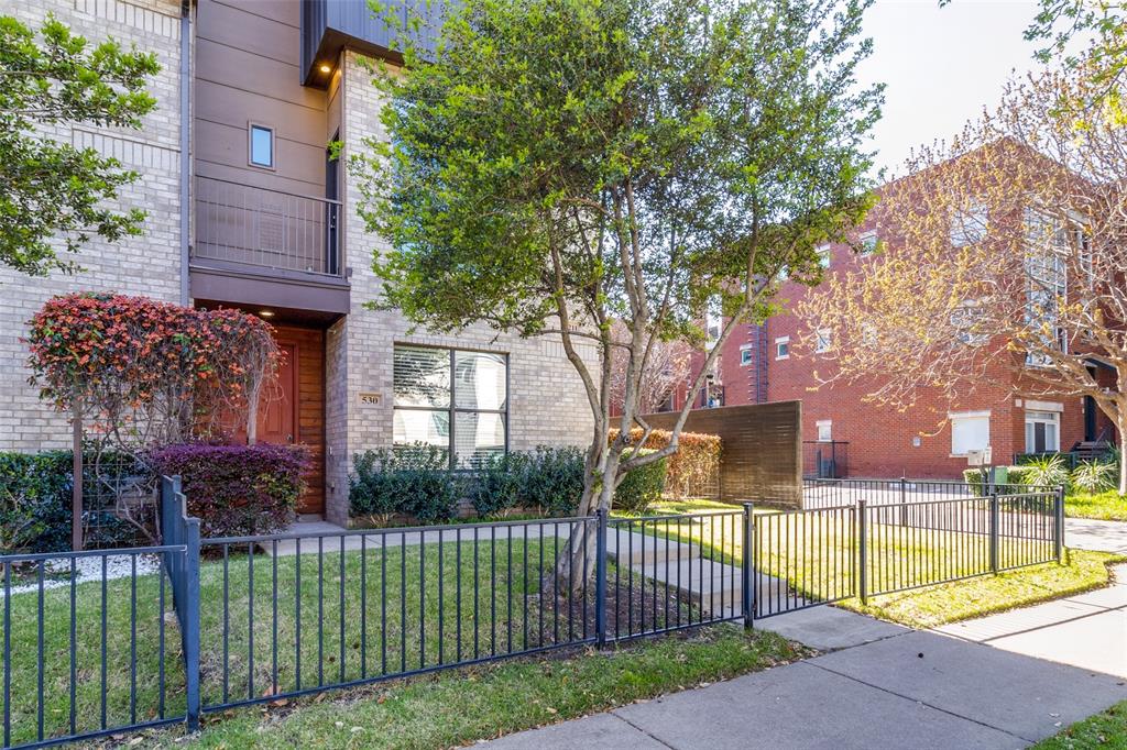 4211 Rawlins Street, Unit 530 Dallas, TX 75219 - Photo 2 of 33 a view of a house with a small yard and large trees