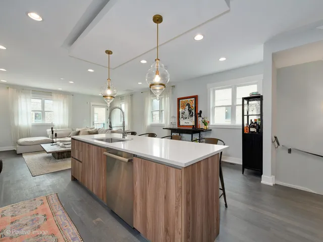 a large kitchen with kitchen island a stove a sink a center island and couches