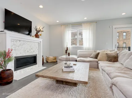 a living room with furniture a flat screen tv and a fireplace