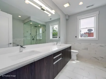 a bathroom with a sink double vanity granite and a toilet