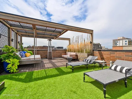 a view of a backyard with couches plants and large trees